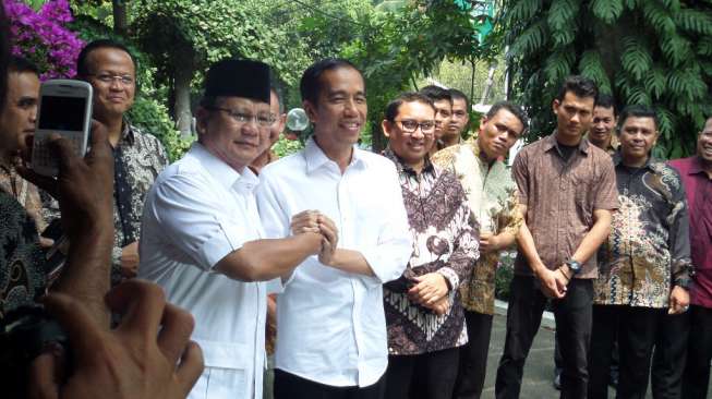 Presiden Joko Widodo (kanan) berjabat tangan dengan Prabowo Subianto, di Jakarta, Jumat (17/10) [suara.com/Bowo Raharjo].