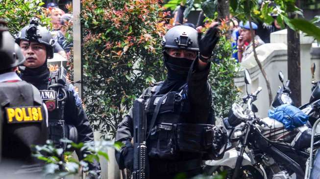 Petugas kepolisian bersenjata lengkap berusaha melumpuhkan terduga teroris di Kantor Kelurahan Arjuna, Bandung, Jawa Barat, Senin (27/2). [Antara]