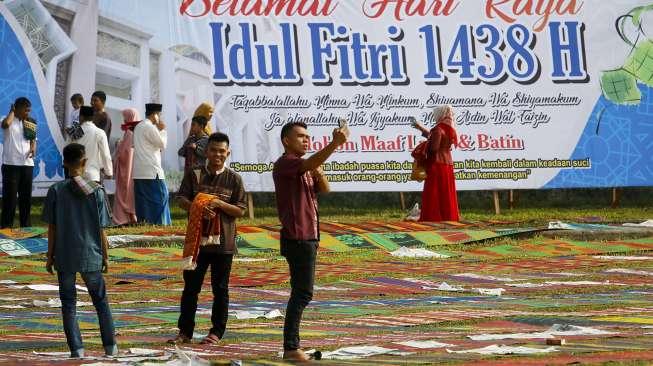 Ribuan umat muslim melaksanakan Salat Idul Fitri 1438 Hijriah di Lapangan Merdeka, Kota Solok, Sumatera Barat, Minggu (25/6). [Suara.com/Kurniawan Mas'ud]