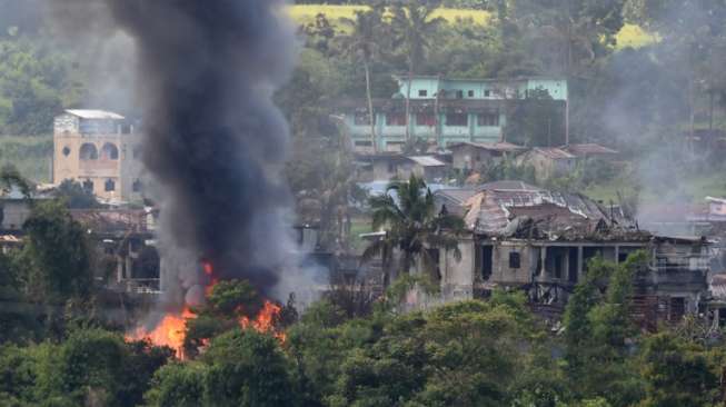 Rumah terbakar di Marawi setelah dibom dari udara. (AFP)