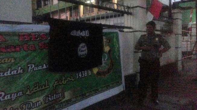 Bendera Hitam ISIS dipasang orang misterius di pagar Markas Polsek Kebayoran Lama, Jakarta Selatan, Selasa (4/7/2017). [Suara.com/Agung Sandy Lesmana]
