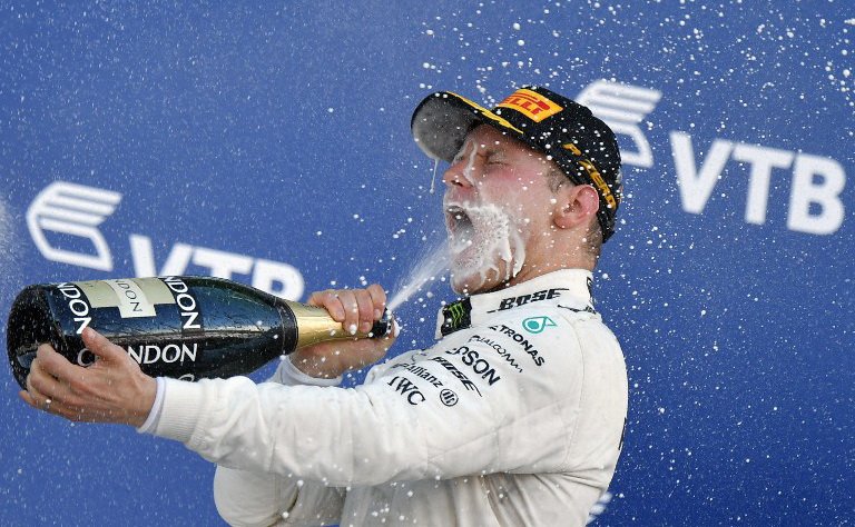 Pebalap Mercedes, Valtteri Bottas, merayakan kemenangannya dengan sampanye usai memenangi balapan F1 GP Rusia di Sirkuit Sochi, Minggu (30/4/2017). [AFP]