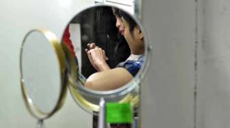 Seorang pengunjung mencoba cincin di sentra penjualan emas, Permata Cikini di Jalan Pegangsaan Barat,  Jakarta, Sabtu (15/2). [MATAMATA/ Adrian Mahakam]