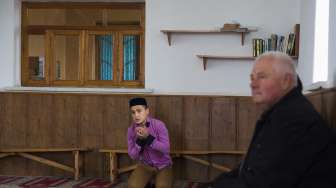 Seorang pemuda Krimea tengah berdoa di dalam Masjid Khan Chair, Bakchisaray, Jumat (7/3/2014). (Reuters/ Thomas Peter).