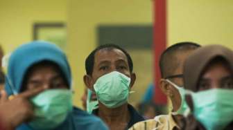 Sejumlah warga mengenakan masker medis saat menunggu giliran berobat di RSUD Petala Bumi, Kota Pekanbaru, Riau, Sabtu (8/3). [Antara/FB Anggoro]