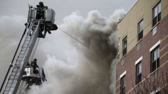 Pemadam kebakaran mencoba memadamkan api di lokasi ledakan New York, Rabu (12/3) [Reuters/Shannon Stapleton].