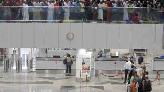 Shalat untuk para penumpang pesawat Malaysia Airlines MH370 yang hilang, di Bandara Internasional Kuala Lumpur, Sepang (13/3). [Reuters/Edgar Su]