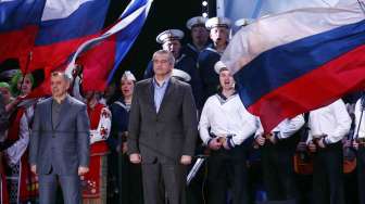 Perdana Menteri Krimea Sergei Aksyonov (tengah) saat diumumkan hasil pemungutan suara dalam referendum Krimea, di Lenin Square, Simferopol, Minggu (16/3). [Reuters/Thomas Peter]