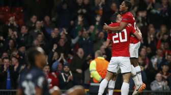 Robin van Persie dan Antonio Valencia rayakan gol ke dua van Persie pada laga leg ke dua babak 16 besar Liga Champions kontra Olympiakos di Old Trafford [19/3]. [Reuters/Phil Noble]