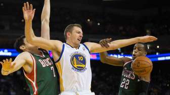 Dua pebasket Milwaukee Bucks melakukan pelanggaran terhadap pebasket Golden State Warriors David Lee (tengah) dalam pertandingan di Oracle Arena, Kamis (20/3). [Reuters/Kelley L Cox]