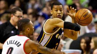 Pebasket Portland Trail Blazers Damian Lillard berusaha merebut bola dari pebasket Utah Jazz Trey Burke dalam pertandingan di Moda Center, Jumat (21/3). [Reuters/Craig Mitchelldyer]