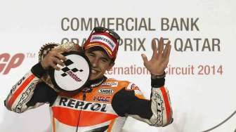 Pembalap MotoGP Spanyol Marc Marquez di atas podium MotoGP Qatar di sirkuit Losail, Doha, Qatar (23/3). [Reuters/Stringer]