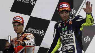 Valentino Rossi (kanan) dan Marc Marquez di sirkuit Losail, Doha, Qatar (23/3). [Reuters/Stringer]