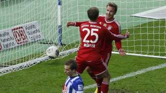 Mario Goetze (kanan) dan Thomas Mueller usai membobol gawang Hertha Berlin di liga Jerman, di Berlin, Selasa (25/3). [Reuters/Fabrizio Bensch]