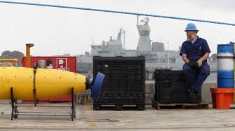 Pekerja menjaga Phoenix, robot pemetaan bawah air di pangkalan AL HMAS Stirling, Perth, Australia, Minggu (30/3). [Reuters/Jason Reed]  