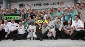 Pebalap Lewis Hamilton foto bersama tim Mercedes di F1 GP Malaysia di sirkuit Sepang, Minggu (30/3). [Reuters/Edgar Su]