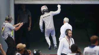 Pebalap Mercedes Lewis Hamilton usai memasuki finish di F1 GP Malaysia di sirkuit Sepang, Minggu (30/3). [Reuters/Edgar Su]