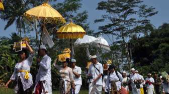 Umat Hindu membawa berbagai macam sesaji menyusuri persawahan untuk melaksanakan upacara Melasti di mata air Tuk Mas, Grabag, Magelang, Jawa Tengah, Sabtu (29/3). [Antara/Anis Efizudin]