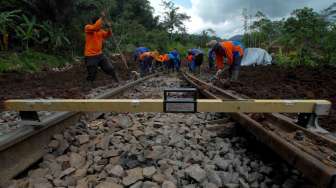 Petugas PT. KAI memperbaiki bantaran rel dengan melakukan pemadatan secara manual pasca kecelakaan kereta api Malabar diperlintasan kereta api KM 244+0/1, di Kampung Terung, Mekarsari, Tasikmalaya, Jawa Barat, Kamis (10/4). [Antara/Adeng Bustomi]