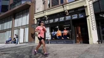 Seorang pelari melintas di depan toko di lokasi lomba lari maraton di Boylston Street, Boston, Massachusetts, Senin (14/4). [Reuters/Dominick Reuter] 