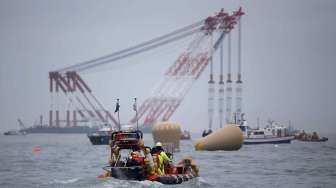 Crane raksasa lepas pantai dikerahkan di lokasi tenggelamnya kapal feri Sewol di perairan Korea Selatan, Jumat (18/40). [Reuters/Kim Hong-Ji]