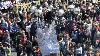 Seorang pengunjukrasa membentangkan spanduk di sela misa Paskah di Basilika Santo Petrus, Vatikan, Minggu (20/4/2014). Tak jelas apa yang dituntut pengunjukrasa ini.  (Foto: Reuters/ Alessandro Bianchi))