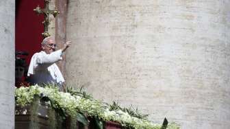 Paus Fransiskus melambaikan tangannya usai menyamapikan pesan \"Urbi et Orbi\" dalam misa Paskah di Basilika Santo Petrus, Vatikan, Minggu (20/4/2014). (Foto: Reuters/ Alessandro Bianchi)