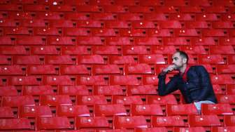 Seorang fans Liverpool duduk termenung sendirian usai kemenangan Chelsea di Anfield [Reuters/Darren Staples]