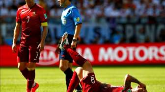 Cristiano Ronaldo (kiri) menatap rekannya yang cedera, Hugo Almeida, Senin (16/6/2014), di lapangan. [Reuters/Darren Staples]