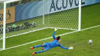 Penjaga gawang Meksiko, Guillermo Ochoa, terjun menghalau bola saat timnya melawan Brasil di Piala Dunia 2014, Rabu (18/6) [Reuters/Mike Blake].