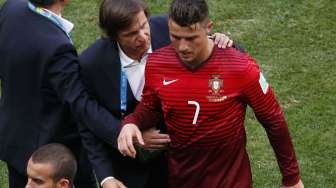 Cristiano Ronaldo masih tampak sedih saat meninggalkan lapangan dan ditenangkan ofisial.(REUTERS/David Gray) 