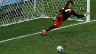 Kiper Meksiko, Guillermo Ochoa, gagal mengantisipasi tendangan penalti Klaas-Jan Huntelaar dalam laga Belanda kontra Meksiko di Fortaleza, Brasil, (29/6). (Reuters/Mike Blake)