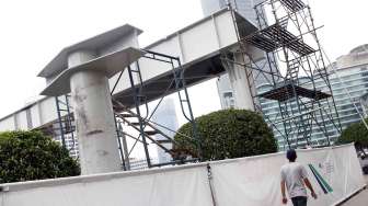 Pemasangan konstruksi jembatan penyeberangan orang (JPO) sementara di depan Plaza Indonesia, Bundaran Hotel Indonesia sebagai pengganti JPO yang akan dibongkar di depan Hotel Pullman Jakarta, Kamis (3/7). [suara.com/Adrian Mahakam]
