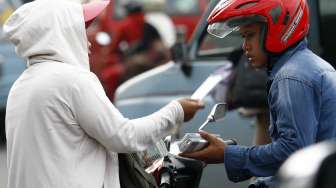 Pedagang pecahan uang kecil di depan Museum Bank Mandiri Jakarta, Selasa (8/7). [suara.com/Adrian Mahakam]