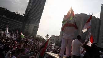 Aksi Kemanusiaan menolak agresi Israel terhadap Gaza di Bundaran HI, Jakarta, Jumat (11/7).  [suara.com/Adrian Mahakam]