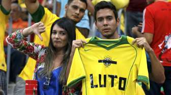 Seorang fans Brasil membentangkan jersey bertuliskan kata yang berarti \"Berduka\" dalam laga perebutan juara tiga Piala Dunia di Brasilia, (13/7). (Reuters/Jorge Silva)