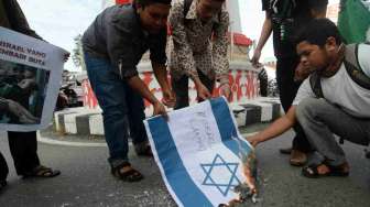Aktivis Himpunan Mahasiswa Islam (HMI) membakar bendera Israel saat aksi menentang serangan Israel terhadap warga Palestina di Palu, Sulawesi Tengah, Sabtu (12/7).  [Antara/Basri Marzuki]