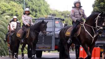 Aparat Kepolisian mengamankan sejumlah ruas jalan protokol dengan mengalihkan arus lalu lintas radius 500 meter dari kantor KPU pusat Jakarta, (22/7). [suara.com/Kurniawan Mas'ud]