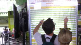 Pemudik masih ramaikan Stasiun Gambir pada H+4, Minggu (3/8). [suara.com/Bagus Santosa]