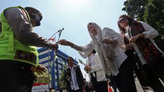 Puluhan relawan Jokowi-JK melakukan aksi damai dengan membagi-bagikan bunga mawar di depan gedung Mahkamah Konstitusi RI di Jakarta, Selasa (5/8). [suara.com/Kurniawan Mas'ud]