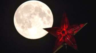 \"Supermoon\" tampak sebagai latar belakang puncak Menara Kremlin di Moskow, Rusia, Minggu (10/8/2014). [Reuters/Maxim Shemetov]