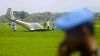 Personel TNI-AU mengamankan pesawat latih TNI-AU, Bravo AS-202 yang jatuh di areal persawahan Jogodayoh, Sukoharjo, Jateng, Selasa (12/8). [Antara/Andika Betha]