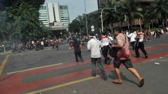 Bentrokan terjadi antara aparat dan massa pendukung Prabowo-Hatta di depan Bundaran Patung Kuda, Jakarta, Kamis (21/8). [suara.com/Adrian Mahakam]