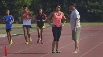 Altelt lari gawang putri pelatnas Asian Games 2014, Dedeh Erawati (kiri) berbincang dengan pelatihnya, Fahmi Fahrezzy (kanan) ketika berlatih fisik di Stadion Madya Senayan, Jakarta, Sabtu (13/9). [Antara/Saptono]