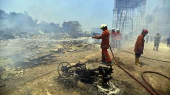 Petugas pemadam kebakaran memadamkan api yang membakar sejumlah rumah warga di kawasan Cipinang Besar Utara, Jatinegara, Jakarta Timur, Rabu (24/9). [Antara/Widodo S. Jusuf]