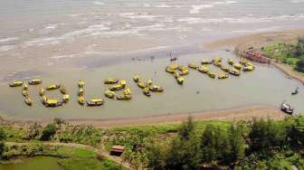 Warga Batang membentuk tulisan \"Tolak PLTU\" dengan konfigurasi perahu sebagai aksi bersama Greenpeace menolak rencana pembangunan pembangkit listrik bertenaga batubara di Desa Ponowareng, Batang, Jawa Tengah, Rabu (24/9). [Antara/Yudhi Mahatma]