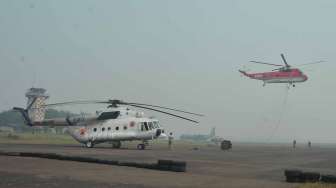 Helikopter milik BNPB yang bertugas melakukan penyiraman titik api terhenti kegiatannya sementara akibat menebalnya kabut asap di  Bandara Sultan Mahmud Badaruddin II Palembang, Sumsel, Jumat (26/9).[Antara/Feny Selly]   