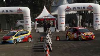 Aksi para pebalap beradu tandem di lintasan kembar dengan handicap slalom dalam ajang kompetisi \"IIMS Gymkhana Race War 2014\" di Loading Bay Hall D Indonesia International Motor Show 2014 Jakarta, Sabtu (26/9). [suara.com/Kurniawan Mas'ud]