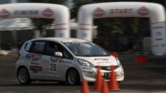 Aksi para pebalap beradu tandem di lintasan kembar dengan handicap slalom dalam ajang kompetisi \"IIMS Gymkhana Race War 2014\" di Loading Bay Hall D Indonesia International Motor Show 2014 Jakarta, Sabtu (26/9). [suara.com/Kurniawan Mas'ud]