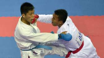 Karateka Indonesia Jintar Simanjuntak (kanan) melepaskan pukulan ke Karateka Korea Utara, Songji Kang (bawah) pada seperdelapan final Komite Putra -67 kg Asian Games ke-17 di Gyeyang Gymnasium, Incheon, Korsel, Kamis (2/10). [Antara/Saptono]